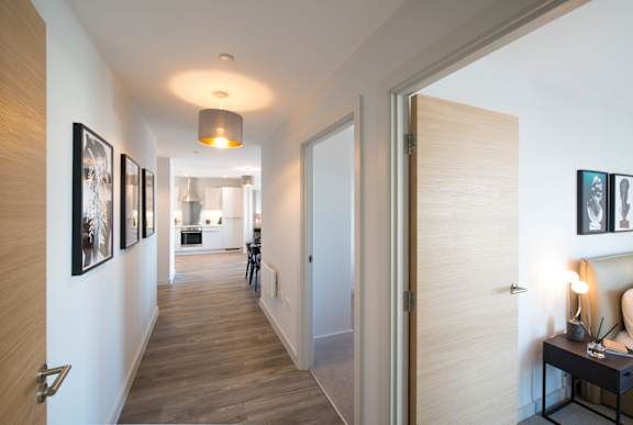A hallway with a light on the ceiling and pictures on the wall.