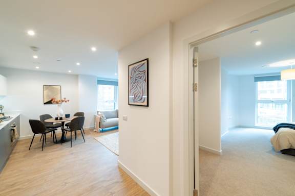 A modern living room with a dining table and chairs.