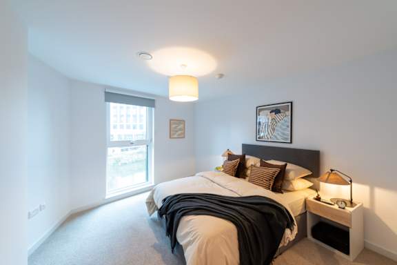 A bedroom with a large bed and a window.