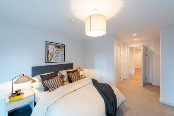 A bedroom with a large bed and a picture on the wall.