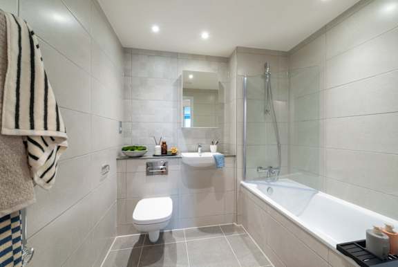 A bathroom with a toilet, sink, and bathtub.