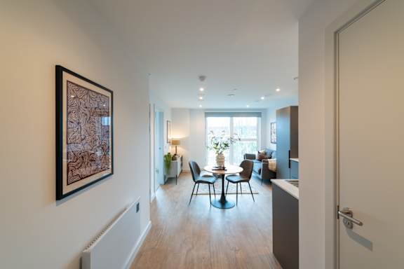 A living room with a table and chairs in the middle of the room.