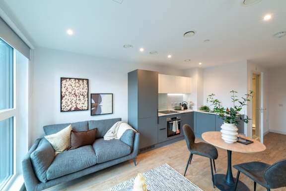 A modern living room with a grey sofa and a round table.