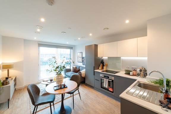 A modern kitchen with a dining table and chairs.