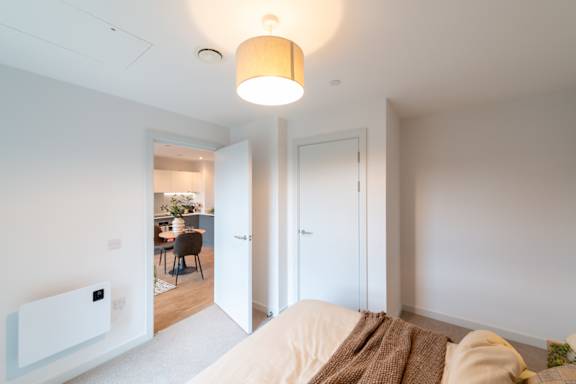 A white room with a couch and a lamp.