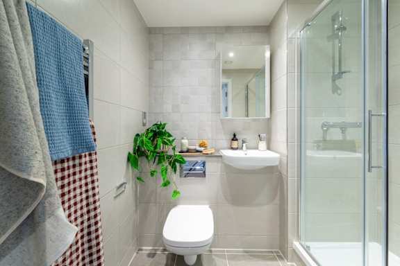 A bathroom with a toilet, sink, and shower.