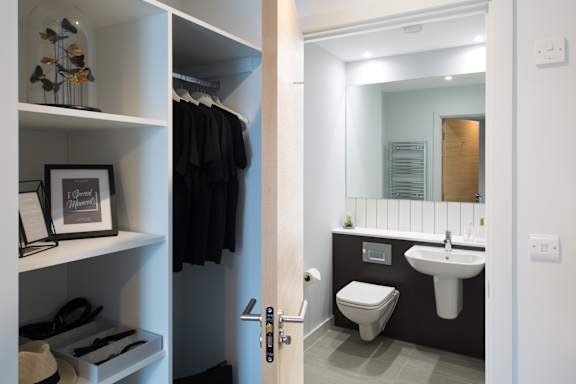 A bathroom with a toilet, sink, and mirror.