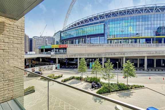 A large glass building with a crane in the background at Alameda Apartments, Wembley, HA9 0HS