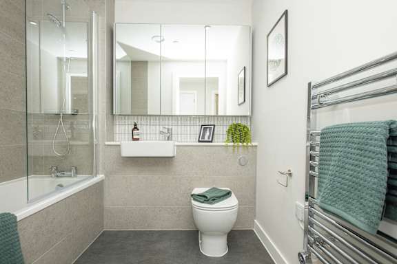 A bathroom with a white toilet and a glass shower stall.
