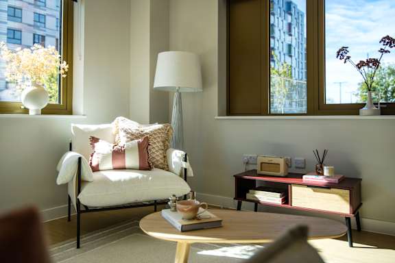 A living room with a white chair and a table with a book on it.