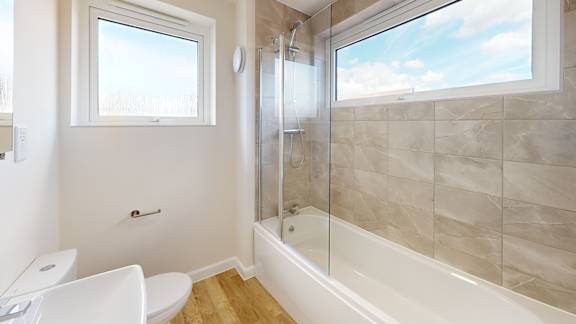 A bathroom with a toilet, tub, and window.
