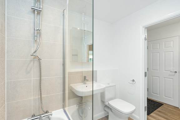 A white toilet sits next to a sink in a bathroom.