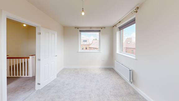 A room with a window and a radiator on the wall.