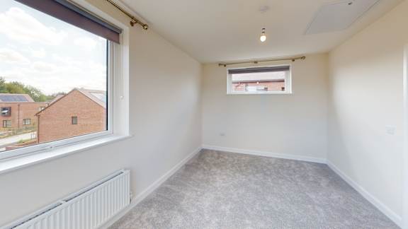 A room with a window and a radiator on the wall.