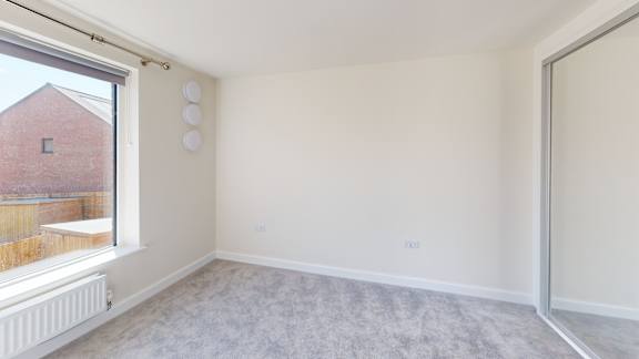 A room with a window and a radiator on the wall.