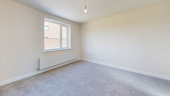 A room with a window and a radiator on the wall.