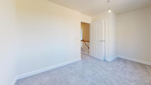 A room with white walls and a grey carpet.