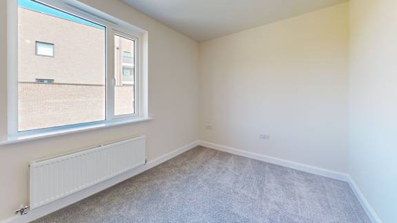 A room with a window and a radiator on the floor.