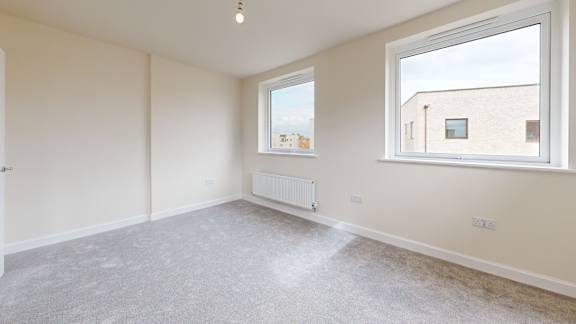 A room with a window and a radiator on the wall.