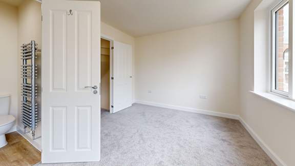 A white door is open in a room with a carpeted floor.