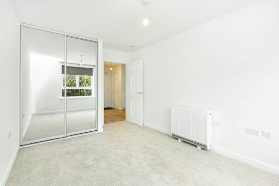 A room with a sliding glass door and a white wall.