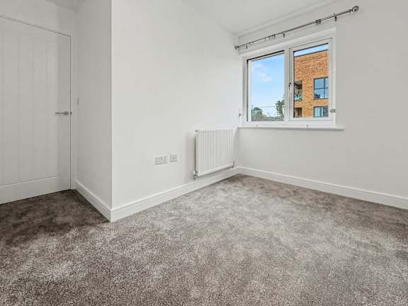 A room with a window showing a building outside.