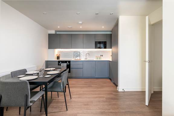 A modern kitchen with a dining table and chairs.