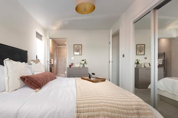 A bedroom with a large bed and a mirror on the wall.