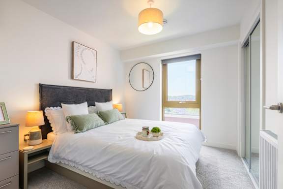 A bedroom with a large bed and a window overlooking a snowy landscape.