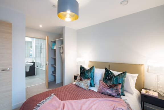 A bedroom with a bed, nightstand, and a lamp.