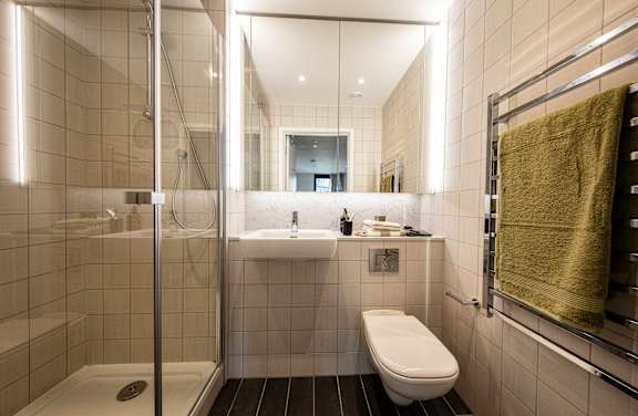 A bathroom with a toilet, sink, and shower.