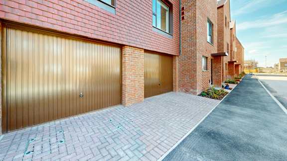 A red brick house with a wooden garage door.