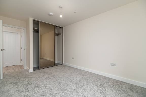 A room with a carpeted floor and a white door.