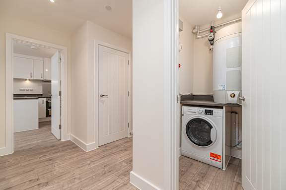 A modern kitchen with a washing machine in the laundry room.