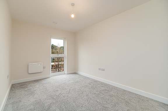 A room with a window and a radiator on the wall.