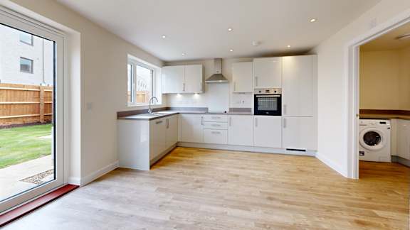 A modern kitchen with white cabinets and appliances.
