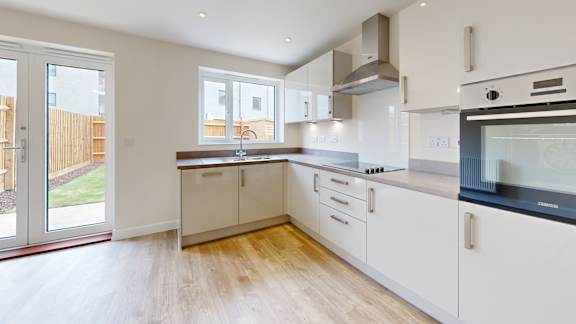 A kitchen with white cabinets and a black stove top oven.