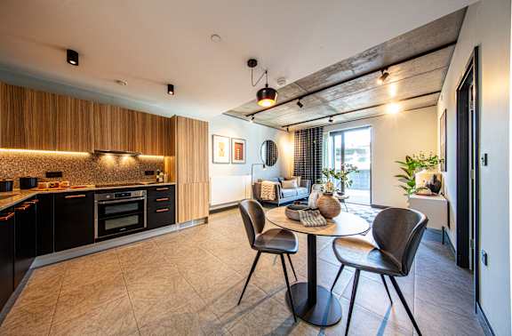 A modern kitchen with a dining table and chairs.