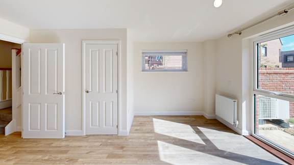 A room with two white doors and a window.