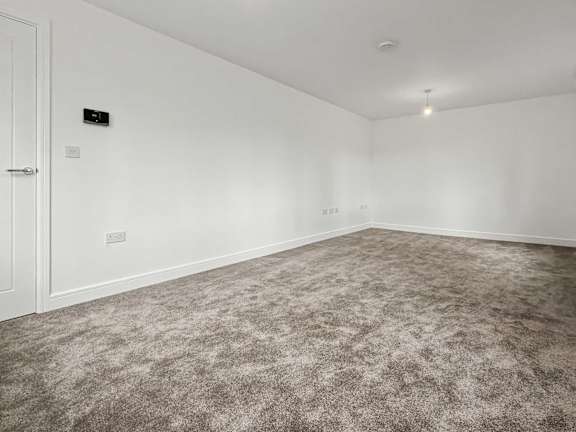 A room with a carpeted floor and a white door.