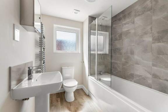 A bathroom with a white sink, toilet, and a walk-in shower at Origins Apartments, Cambridge