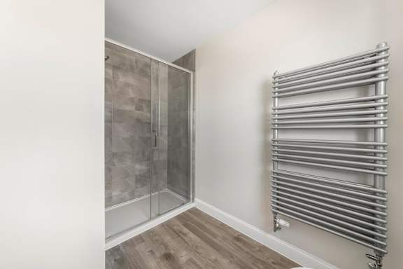 A bathroom with a walk-in shower and a towel warmer at Origins Apartments, Cambridge, CB3 0UX