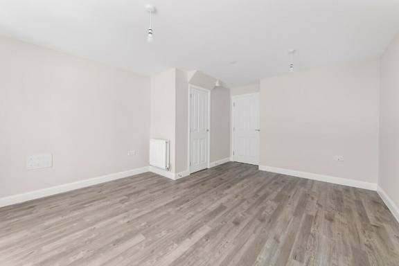 A room with wooden flooring and a white door at Origins Apartments, Cambridge