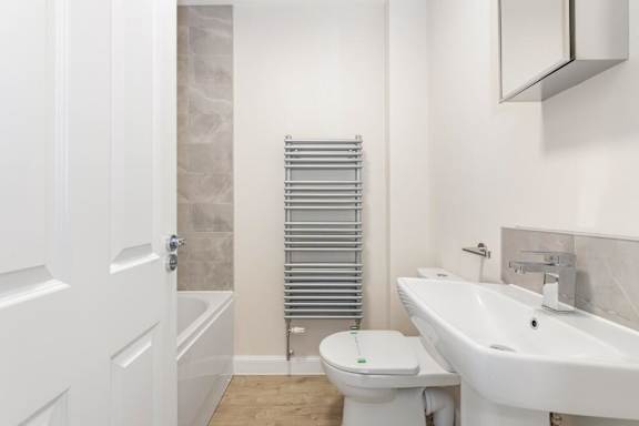 A white toilet sit next to a white sink in a bathroom at Origins Apartments, Cambridge, CB3 0UX