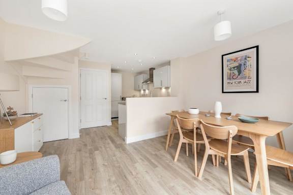 A dining area with a wooden table and chairs at Origins Apartments, Cambridge