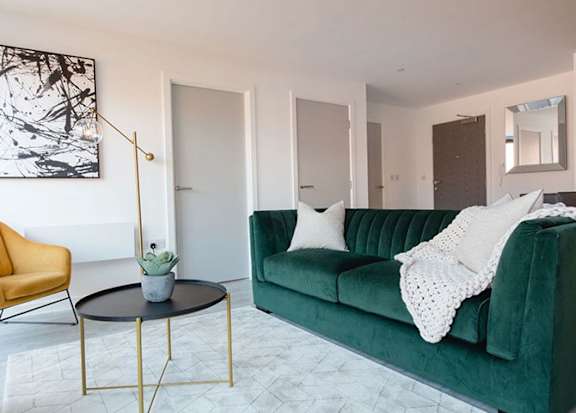 a living room with a green couch and a table a living room with a green couch and a table at Vox Apartments, Manchester, M15 4YD