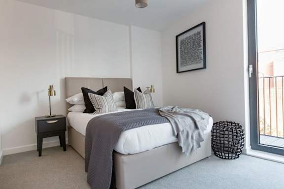 a bedroom with a large bed and a window a bedroom with a large bed and a window at Vox Apartments, Manchester