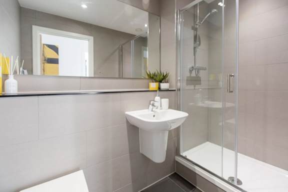 a modern bathroom with a sink and a shower a modern bathroom with a sink and a shower at Vox Apartments, Manchester, M15 4YD