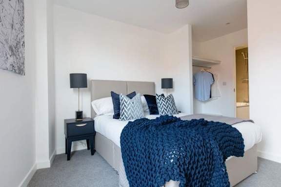 a bedroom with a bed and a blue blanket a bedroom with a bed and a blue blanket at Vox Apartments, Manchester, M15 4YD