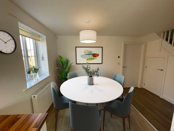 A dining room with a white table and grey chairs.